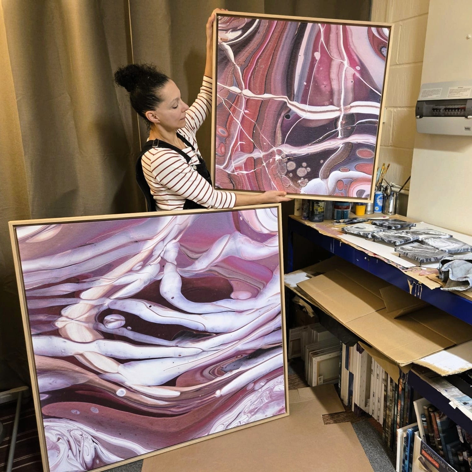 Artist in workshop with 2 large canvas prints in oak frame