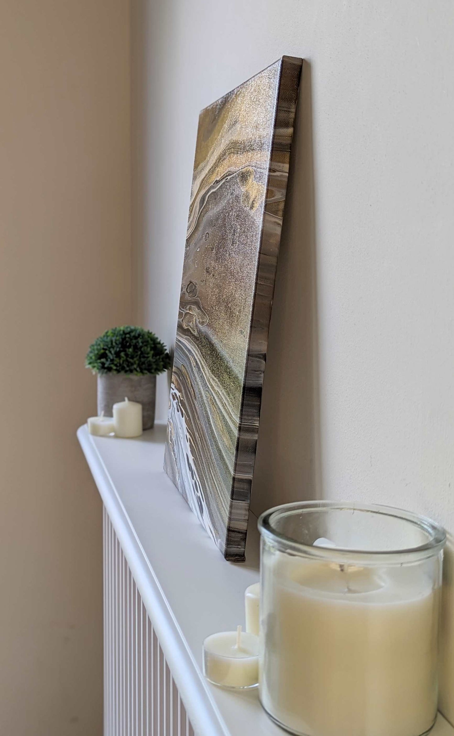 Canvas on shelf – side view of original abstract painting in grey hues with gold made with professional grade acrylic paint.