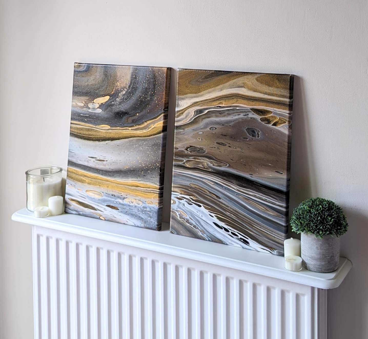 Canvas on shelf – frontal view of original abstract diptych in grey hues with gold made with professional grade acrylic paint.