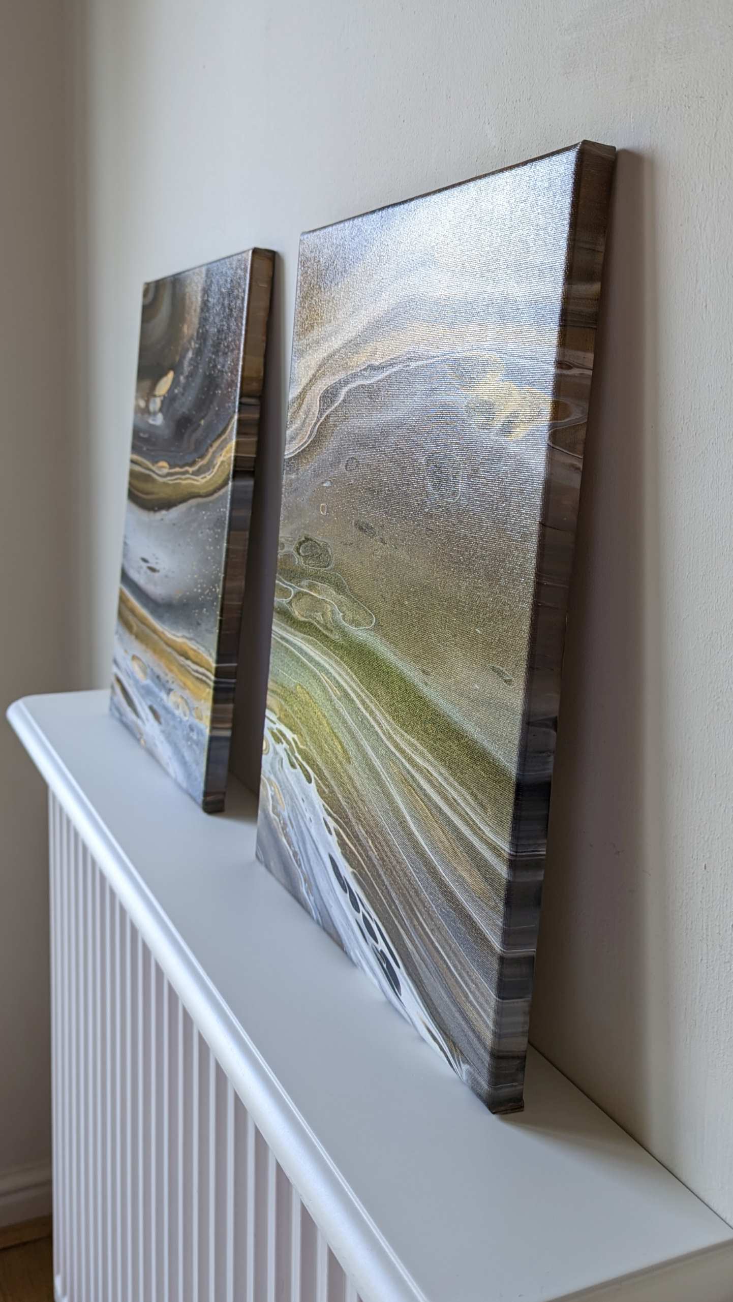 Canvas on shelf – side view of original abstract diptych in grey hues with gold made with professional grade acrylic paint.