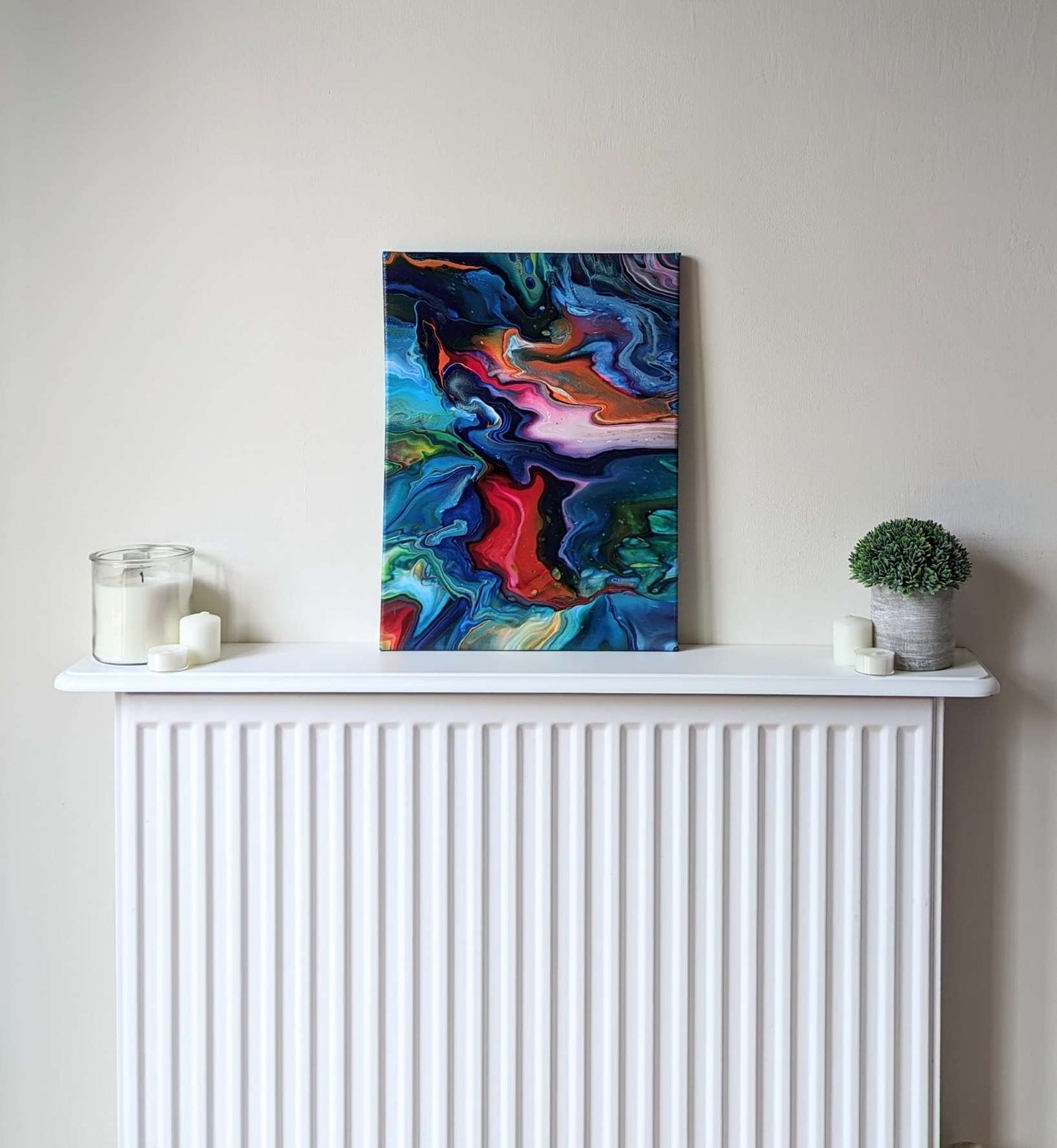 Canvas on shelf – frontal view of original abstract painting in vibrant colours made with professional grade acrylic paint.