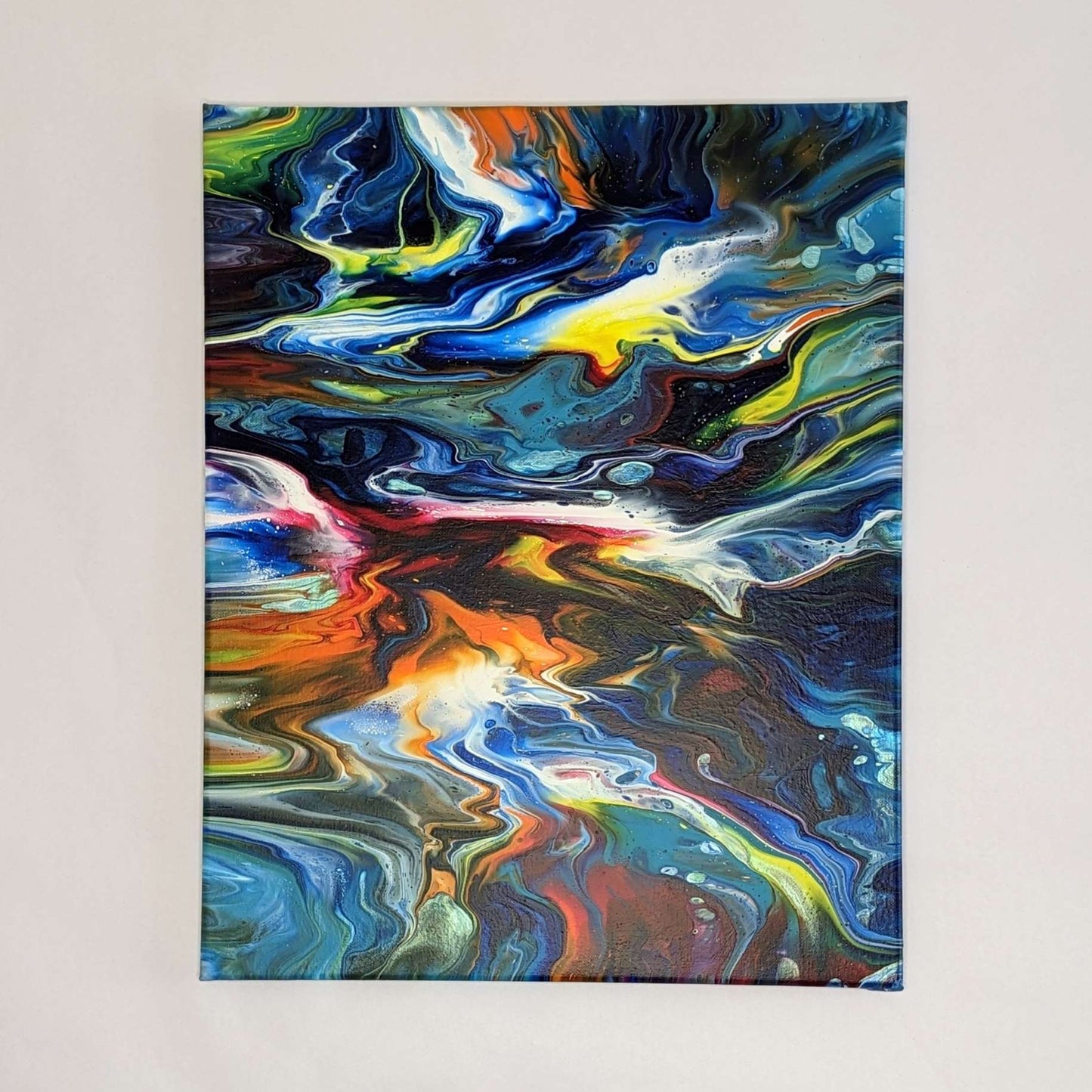 Canvas on wall – frontal view of original abstract painting in vibrant colours made with professional grade acrylic paint.