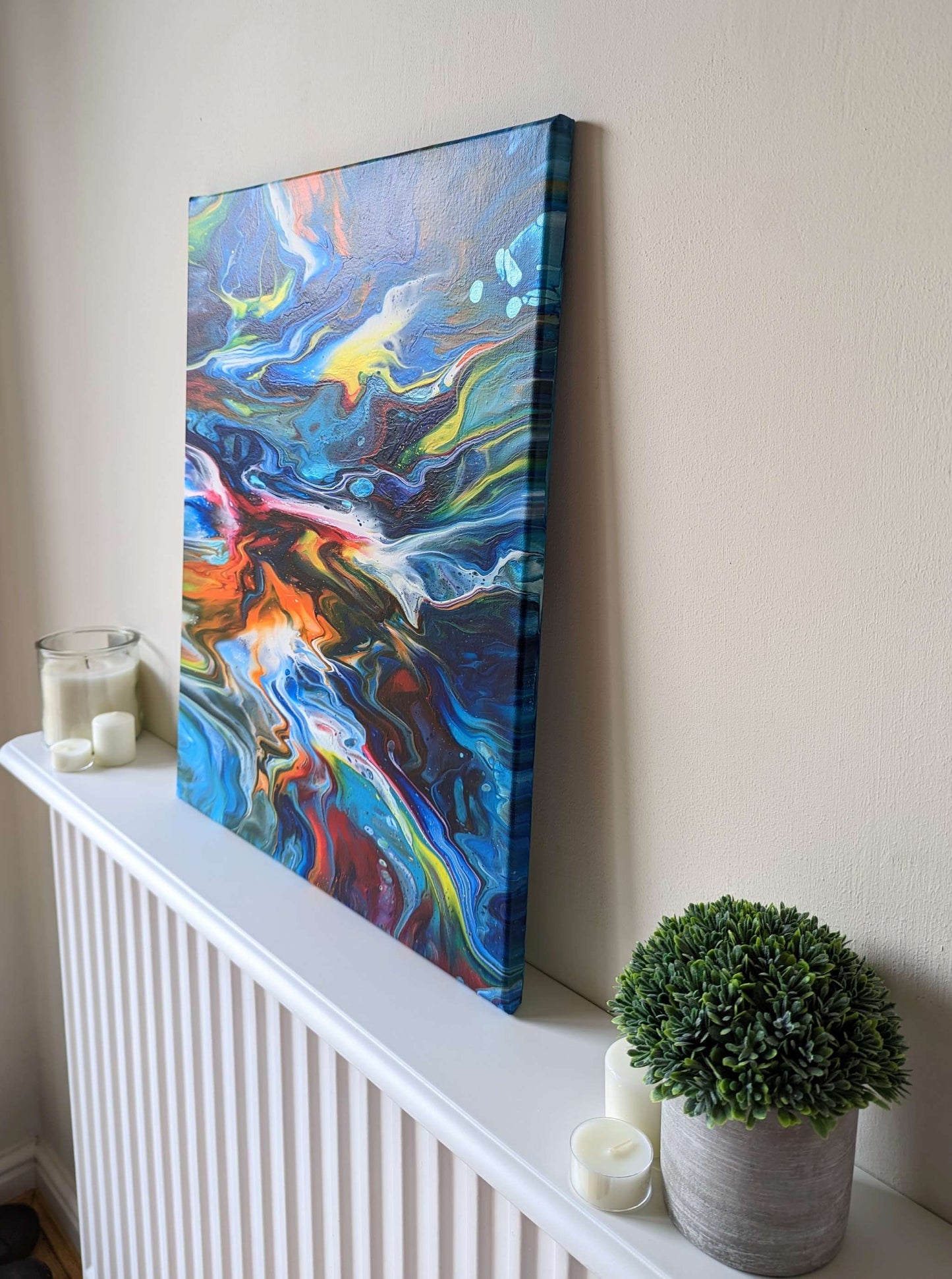 Canvas on shelf – side view of original abstract painting in vibrant colours made with professional grade acrylic paint.