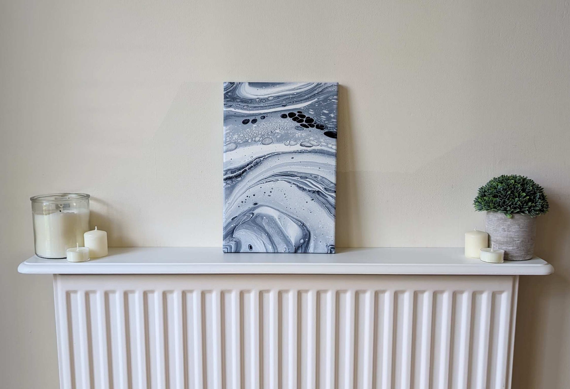 Canvas on shelf – frontal view of original abstract painting. Made with professional grade acrylic paint: Payne’s grey and white.