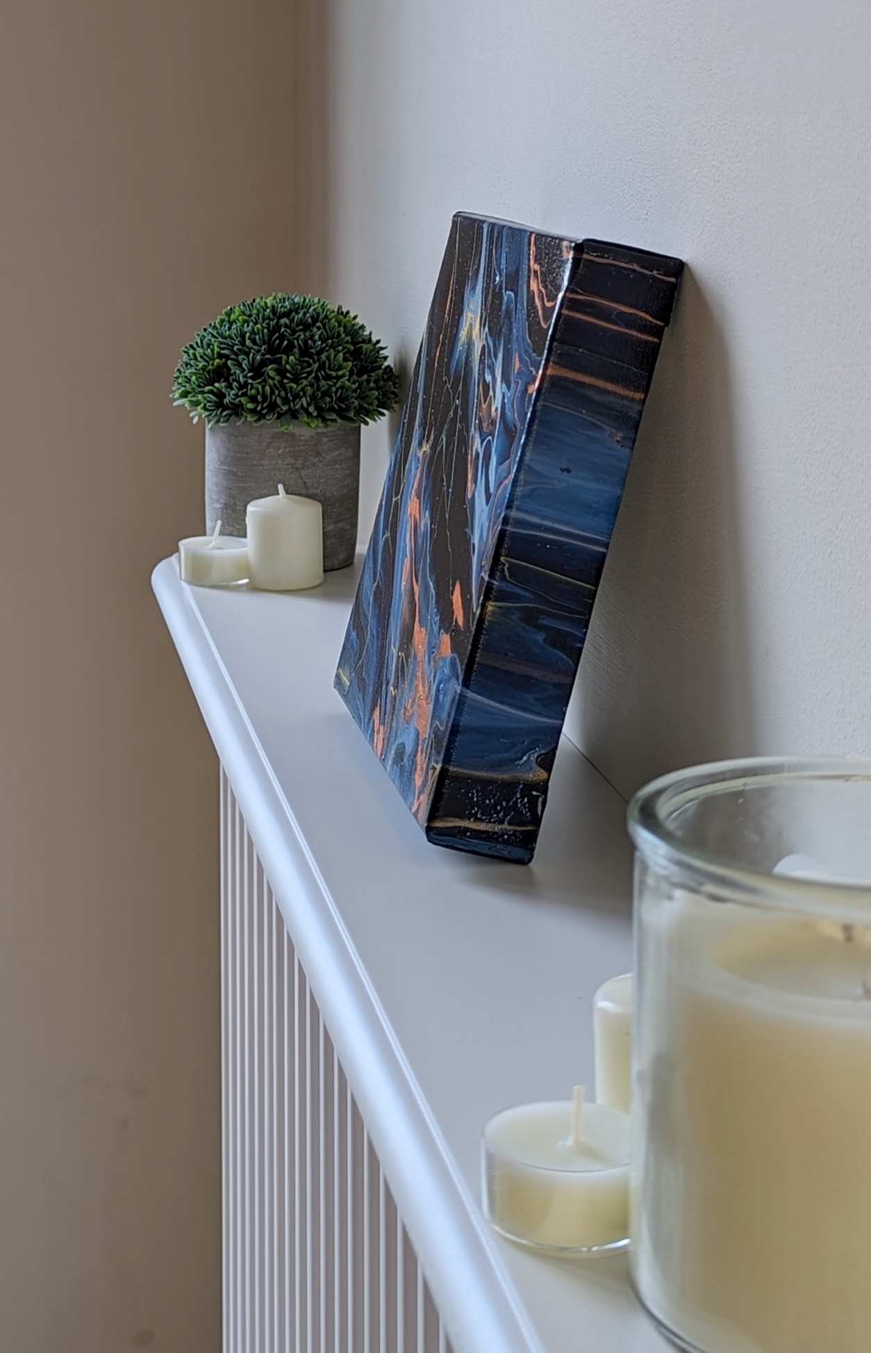 Canvas on shelf – side view of original abstract painting made with Prussian blue, copper, and gold professional grade acrylic paint.