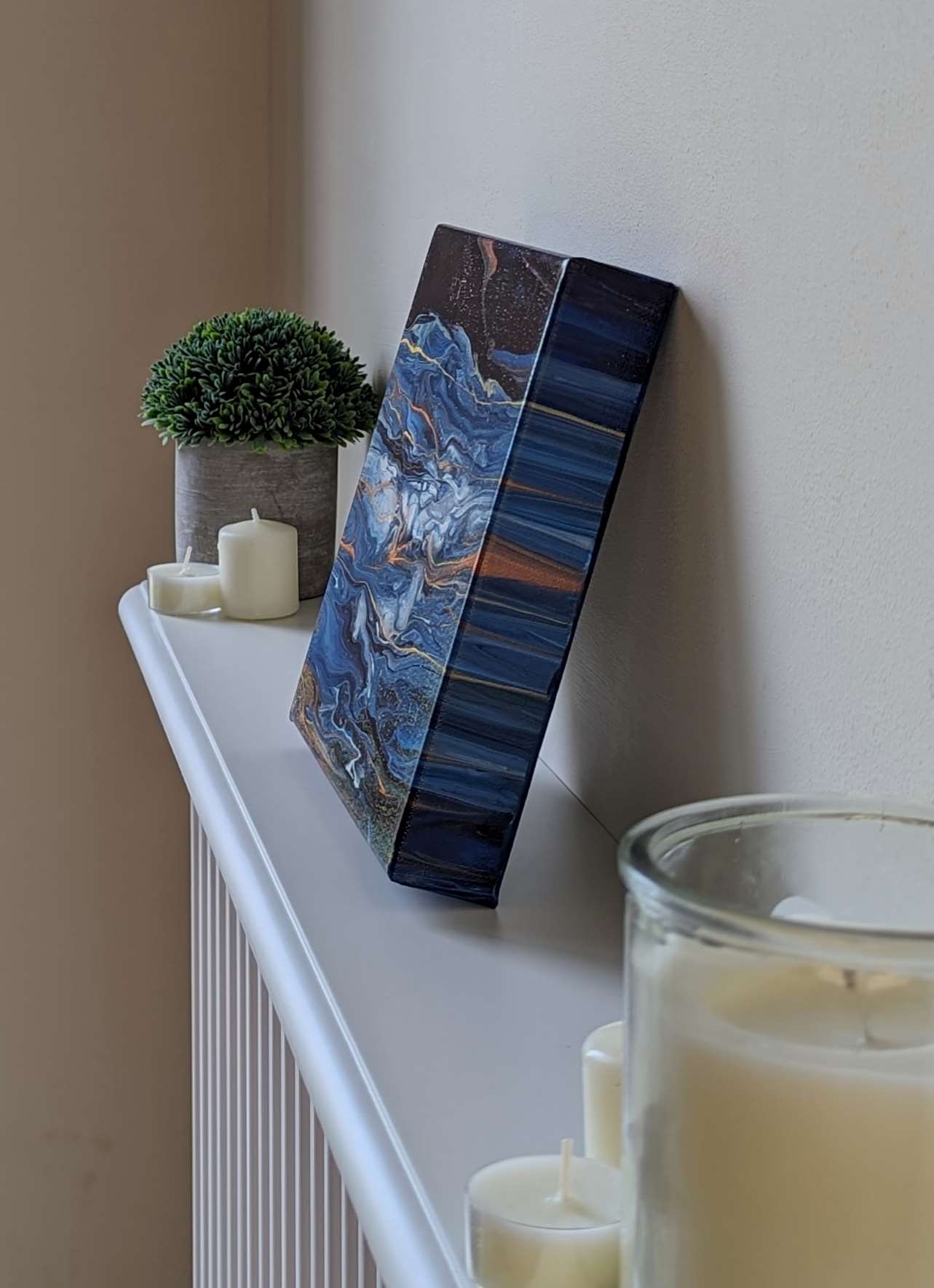 Canvas on shelf – side view of original abstract painting made with Prussian blue, copper, and gold professional grade acrylic paint.